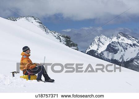 Hiker using laptop on snowy mountain peak View Large Photo Image Stock Image - Hiker using laptop on snowy mountain peak. Fotosearch
