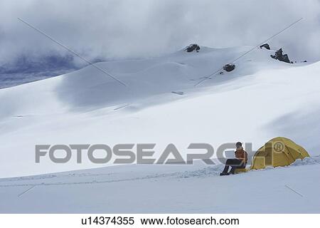 Hiker using laptop outside of tent on snowy mountain peak View Large Photo Image Stock Photography - Hiker using laptop outside of tent on snowy mountain peak. Fotosearch