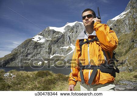 Hiker using walkie-talkie on mountain trail View Large Photo Image Picture - Hiker using walkie-talkie on mountain trail. Fotosearch