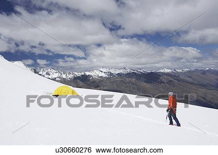 Hiker walking toward tent in snowy mountains View Large Photo Image Stock Photograph - Hiker walking toward tent in snowy mountains. Fotosearch