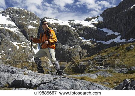 Stock Photo - Hiker with walking sticks in mountains. Fotosearch