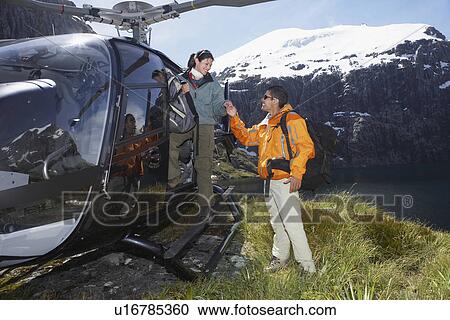 Hikers climbing out of helicopter on mountain peak View Large Photo Image Stock Image - Hikers climbing out of helicopter on mountain peak. Fotosearch