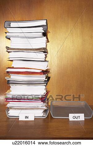 Inbox with stack of paperwork empty outbox on desk View Large Photo Image Picture - Inbox with stack of paperwork empty outbox on desk. Fotosearch