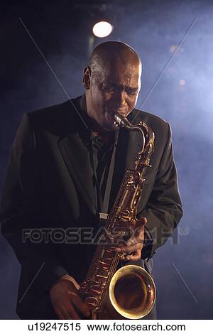 Jazz musician playing saxophone on smokey nightclub stage View Large Photo Image Stock Photography - Jazz musician playing saxophone on smokey nightclub stage. Fotosearch