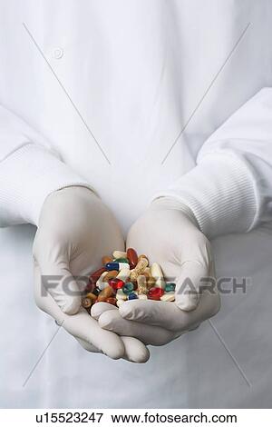 Lab Worker with Hands Full of coloured Pills View Large Photo Image Stock Photo - Lab Worker with Hands Full of coloured Pills. Fotosearch