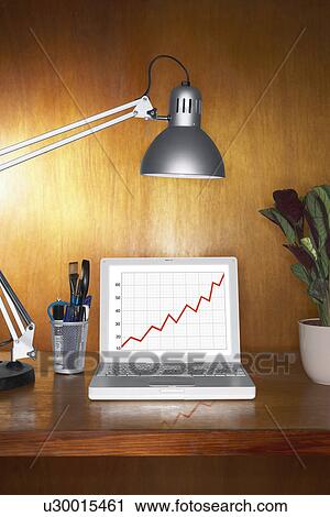 Laptop showing graph and other items on desk View Large Photo Image Stock Image - Laptop showing graph and other items on desk. Fotosearch