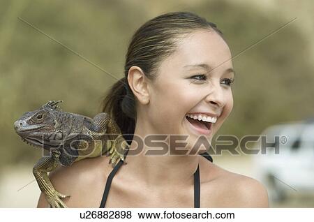 Stock Photo - Laughing Woman with Iguana on Her Shoulder close-up. Fotosearch
