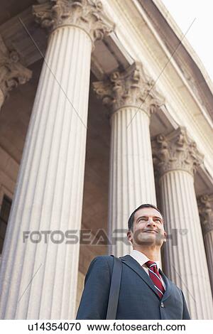 Stock Image - Lawyer outside courthouse low angle view. Fotosearch