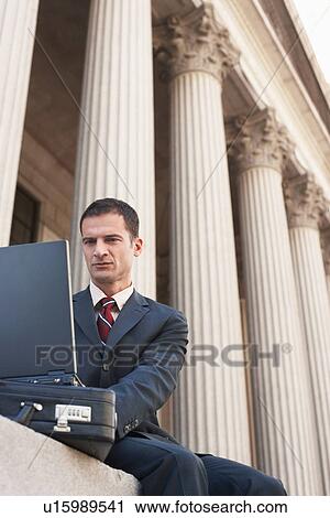 Lawyer using laptop outside courthouse View Large Photo Image Stock Image - Lawyer using laptop outside courthouse. Fotosearch