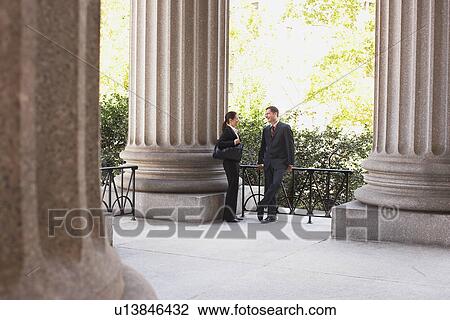 Stock Image - Lawyers talking outside courthouse. Fotosearch