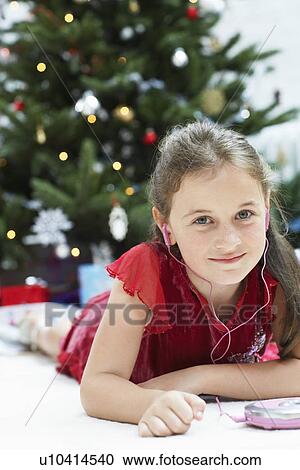 Little Girl lying down by christmas tree Listening to CD Player portrait View Large Photo Image Stock Image - Little Girl lying down by christmas tree Listening to CD Player portrait. Fotosearch