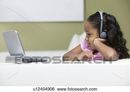 Little Girl on sofa Watching movie on Portable DVD Player side view View Large Photo Image Stock Photograph - Little Girl on sofa Watching movie on Portable DVD Player side view. Fotosearch