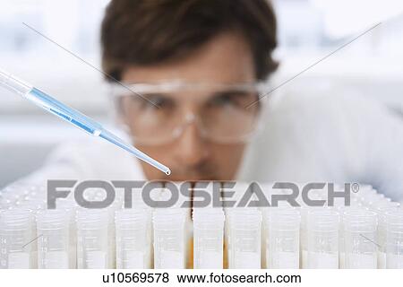 Male lab worker adding drops to test tubes View Large Photo Image Stock Photo - Male lab worker adding drops to test tubes. Fotosearch