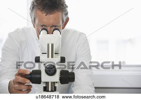 Male lab worker adjusting microscope View Large Photo Image Stock Photo - Male lab worker adjusting microscope. Fotosearch