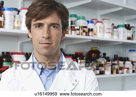 Male lab worker standing pill bottles behind View Large Photo Image Stock Photo - Male lab worker standing pill bottles behind. Fotosearch