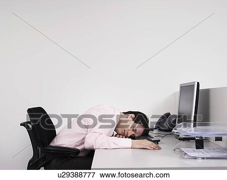 Male office worker asleep at desk in office View Large Photo Image Stock Photo - Male office worker asleep at desk in office. Fotosearch