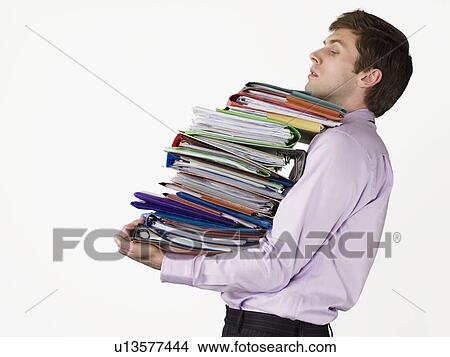 Male office worker carrying heavy binders on white background View Large Photo Image Picture - Male office worker carrying heavy binders on white background. Fotosearch