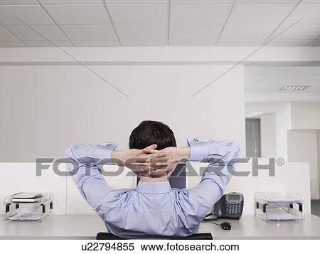 Male office worker relaxing at desk View Large Photo Image Stock Photography - Male office worker relaxing at desk. Fotosearch