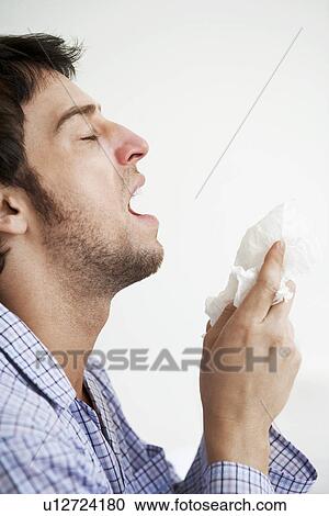 Man about to sneeze into facial tissue View Large Photo Image Stock Image - Man about to sneeze into facial tissue. Fotosearch