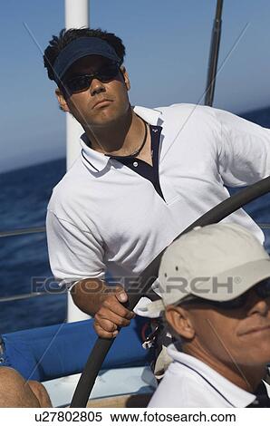 Man at Helm of Sailboat on ocean View Large Photo Image Stock Photography - Man at Helm of Sailboat on ocean. Fotosearch