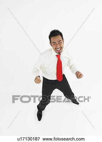 Stock Photo - Man celebrating in studio full length. Fotosearch