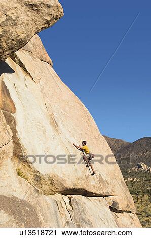 Stock Image - Man Climbing on Cliff. Fotosearch