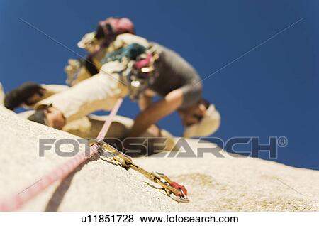 Man Climbing on Cliff view from below (low angle view) View Large Photo Image Stock Photo - Man Climbing on Cliff view from below (low angle view). Fotosearch