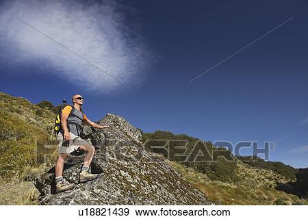 Man climbing up boulder in forest valley View Large Photo Image Stock Photo - Man climbing up boulder in forest valley. Fotosearch