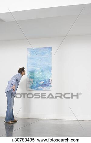 Man contemplating paintings in gallery View Large Photo Image Stock Photography - Man contemplating paintings in gallery. Fotosearch