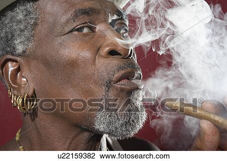 Man exhaling cigar smoke View Large Photo Image Stock Image - Man exhaling cigar smoke. Fotosearch