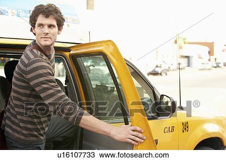 Stock Image - Man exiting taxi in street. Fotosearch