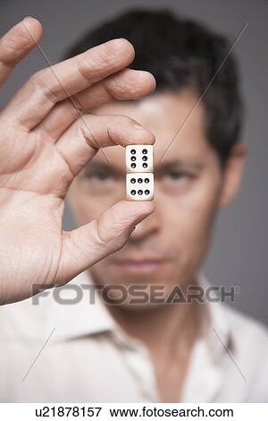 Man holding dice between finger and thumb focus on foreground View Large Photo Image Stock Photo - Man holding dice between finger and thumb focus on foreground. Fotosearch