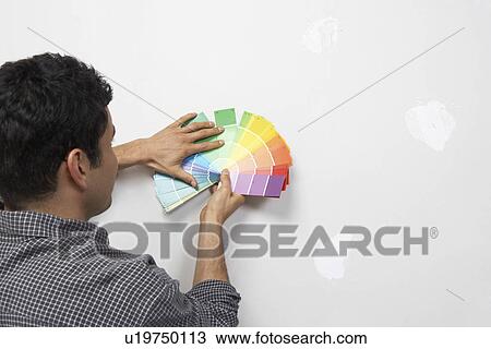 Man holding paint colour samples against interior wall back view View Large Photo Image Stock Image - Man holding paint colour samples against interior wall back view. Fotosearch