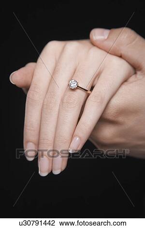 Man holding woman's hand displaying engagement ring close up of hand View Large Photo Image Stock Image - Man holding woman's hand displaying engagement ring close up of hand. Fotosearch