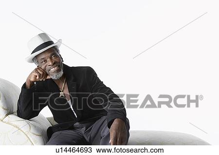 Stock Image - Man in Fedora on Chaise Lounge. Fotosearch