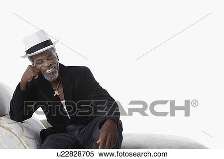 Stock Photography - Man in Fedora on Chaise Lounge. Fotosearch