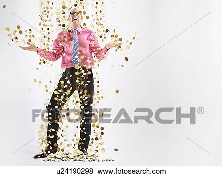 Man in glasses laughing with gold coins falling to floor View Large Photo Image Stock Photo - Man in glasses laughing with gold coins falling to floor. Fotosearch