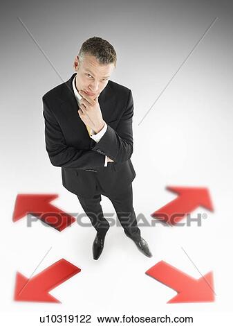 Man in suit in centre of four arrows elevated view full length View Large Photo Image Stock Image - Man in suit in centre of four arrows elevated view full length. Fotosearch
