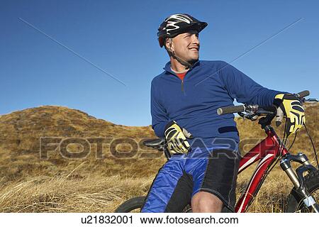 Man leaning on bicycle in field View Large Photo Image Stock Image - Man leaning on bicycle in field. Fotosearch