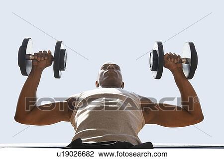 Man Lifting dumbbells low angle view close up View Large Photo Image Stock Image - Man Lifting dumbbells low angle view close up. Fotosearch