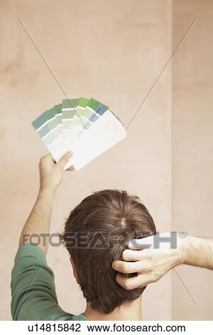Man looking at paint colour swatches in unrenovated room back view View Large Photo Image Stock Image - Man looking at paint colour swatches in unrenovated room back view. Fotosearch