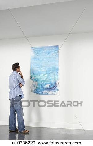 Stock Photo - Man looking observing in art gallery. Fotosearch