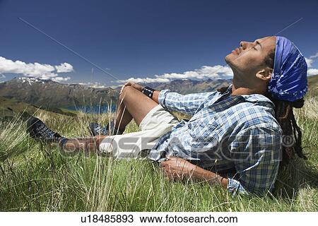 Man lying in field feeling sun View Large Photo Image Stock Image - Man lying in field feeling sun. Fotosearch