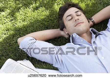 Man lying on grass by newspaper close up elevated view View Large Photo Image Stock Image - Man lying on grass by newspaper close up elevated view. Fotosearch