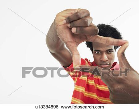 Man making rectangle with fingers in studio View Large Photo Image Stock Photograph - Man making rectangle with fingers in studio. Fotosearch