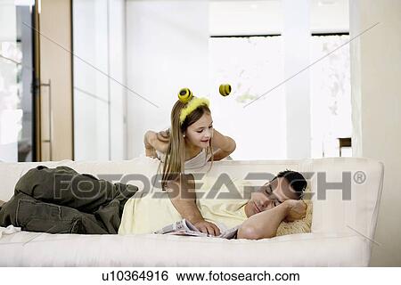 Man napping on sofa with daughter leaning over View Large Photo Image Stock Photograph - Man napping on sofa with daughter leaning over. Fotosearch