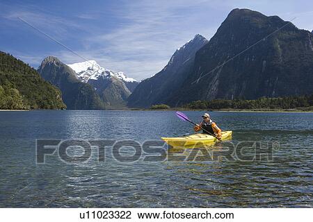 Man paddling kayak in mountain lake View Large Photo Image Stock Image - Man paddling kayak in mountain lake. Fotosearch