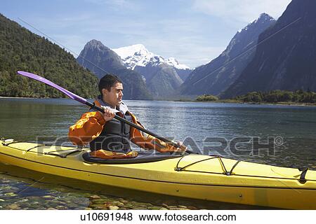 Man paddling kayak in mountain lake View Large Photo Image Stock Photo - Man paddling kayak in mountain lake. Fotosearch