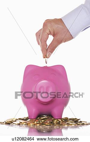 Man putting money in overflowing piggy bank close up of hand View Large Photo Image Picture - Man putting money in overflowing piggy bank close up of hand. Fotosearch