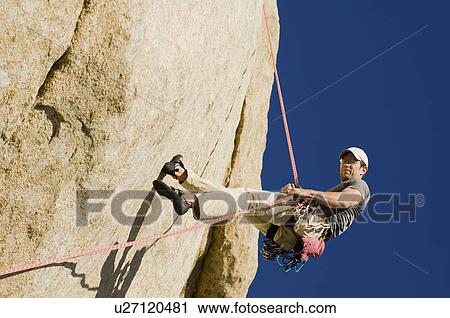 Man Rappelling from Cliff side view View Large Photo Image Stock Image - Man Rappelling from Cliff side view. Fotosearch
